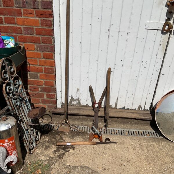 Vintage garden tools including a metal sprinkler and shears.