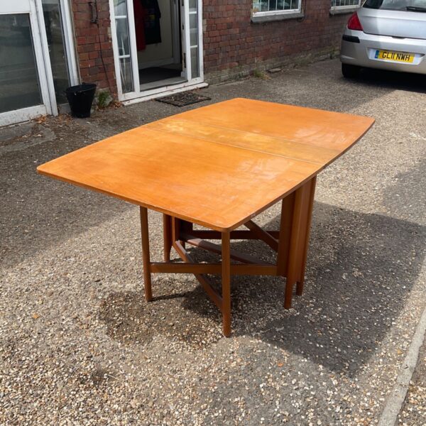 Vintage teak gateleg table in a courtyard setting.
