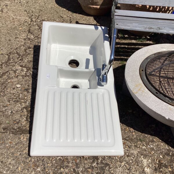 Vintage enamel kitchen sink with chrome tap, ideal for restoration.