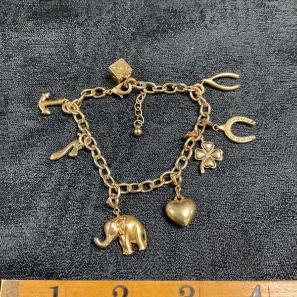 Vintage gold tone lucky charm bracelet with eight charms.