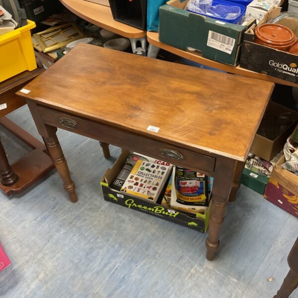 Vintage mahogany side table with carved legs in a room setting.