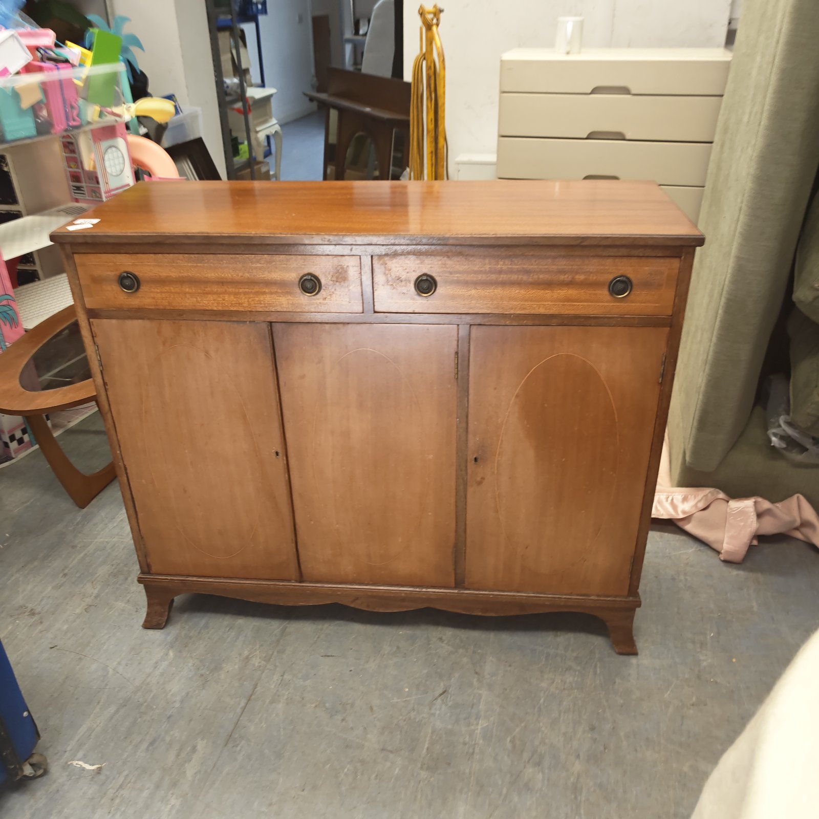 Vintage mahogany sideboard with a curved front and central drawer.