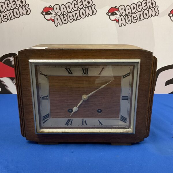Front view of a vintage Garrard mantle clock with Roman numerals.