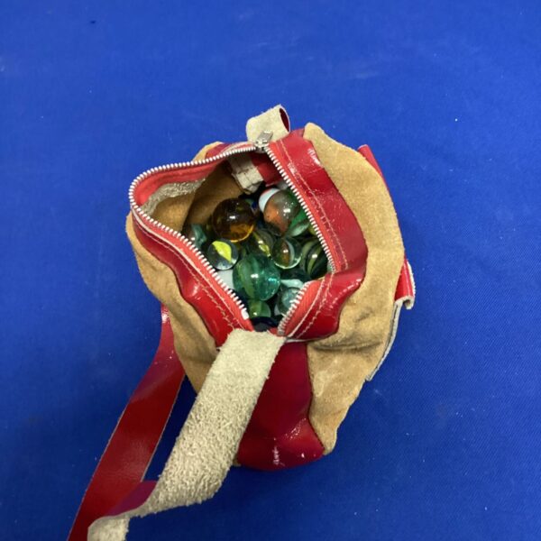 Vintage marble bag filled with colourful glass marbles.