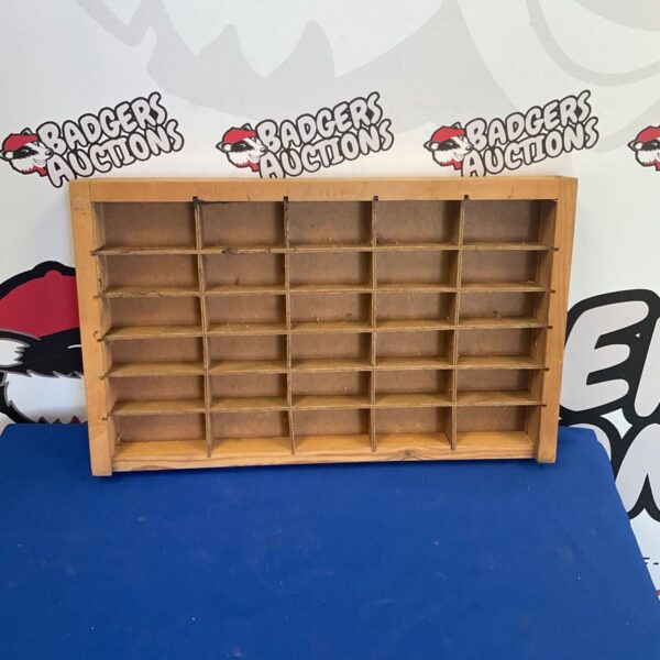Vintage wooden matchbox car storage unit with multiple compartments.