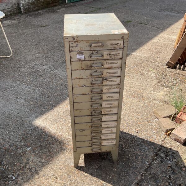 Vintage metal tool drawers with multiple compartments for workshop storage.