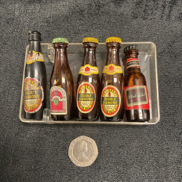 Set of vintage miniature beer bottles including Double Diamond and Black Label.