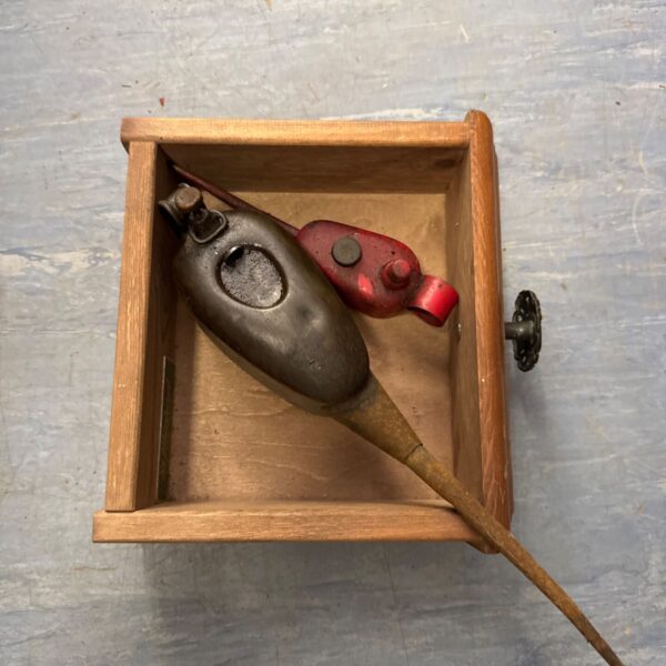 Vintage metal oil dripper can with red handle.