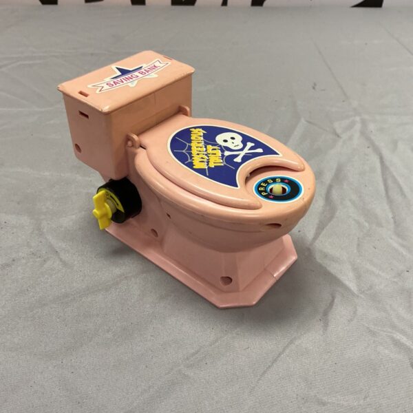 Vintage pink ceramic mystery toilet money box, a collectible novelty item.