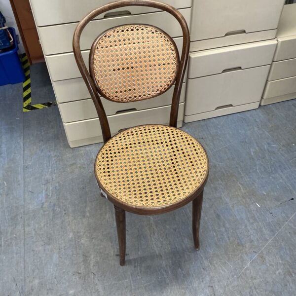 Vintage rattan bedroom chair with woven cane seat and back.