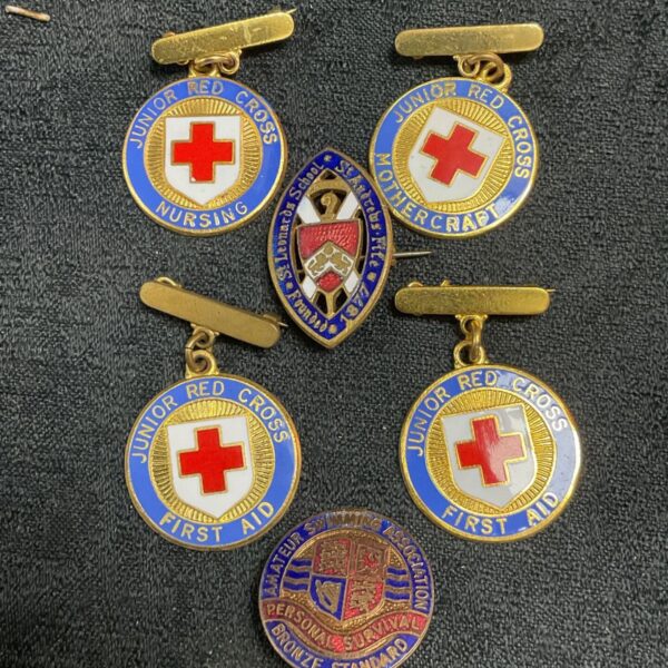 Vintage Red Cross medals and enamel pin badges, a collectible lot.