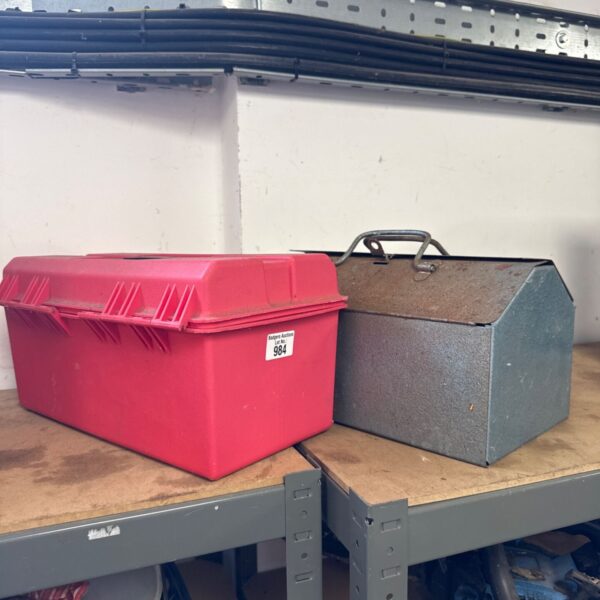 Vintage red metal toolbox with latch closure.