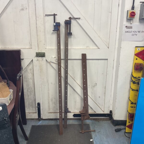 Three vintage metal sash clamps for woodworking projects.