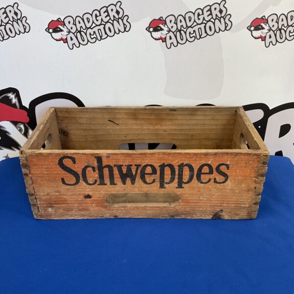 Vintage wooden Schweppes crate with clear branding.