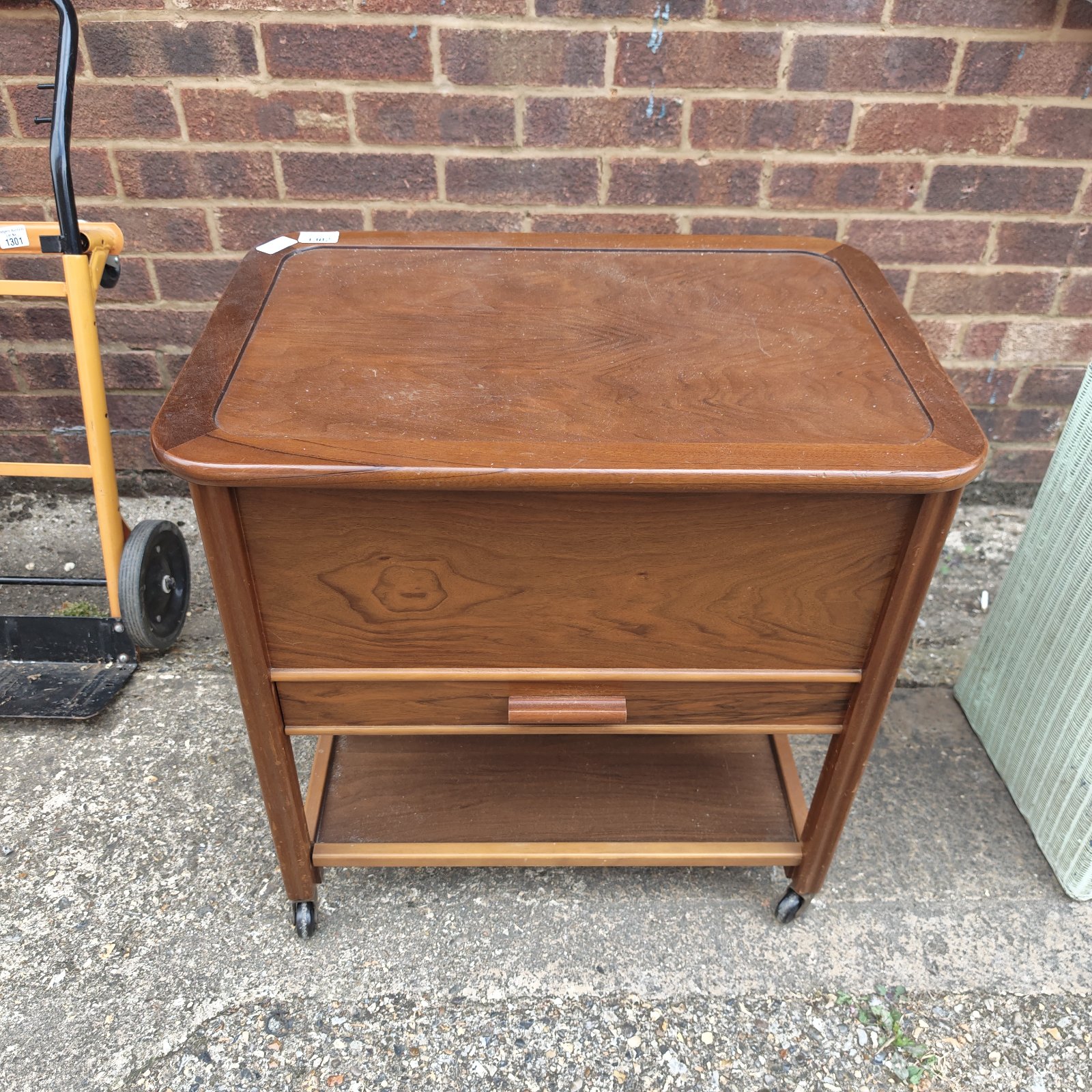 Vintage wooden sewing box with caster wheels for easy movement.