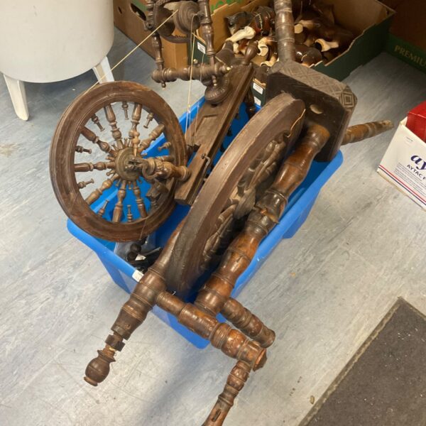 Vintage wooden spinning wheel with a blue base.