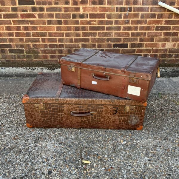 Pair of vintage brown suitcases stacked, antique travel luggage.