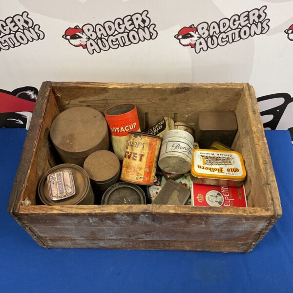 Vintage tin collection displayed inside a weathered Crowley's Brewery crate.