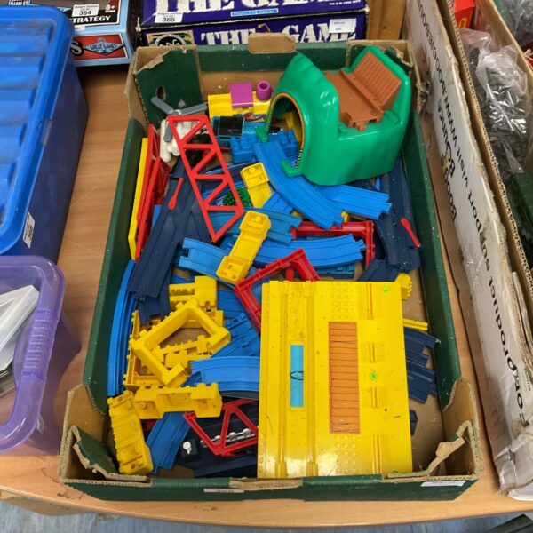 Vintage Tomy Thomas the Tank Engine trains and track pieces in a tray.