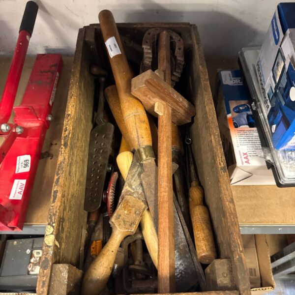 Vintage wooden tray filled with assorted antique hand tools.
