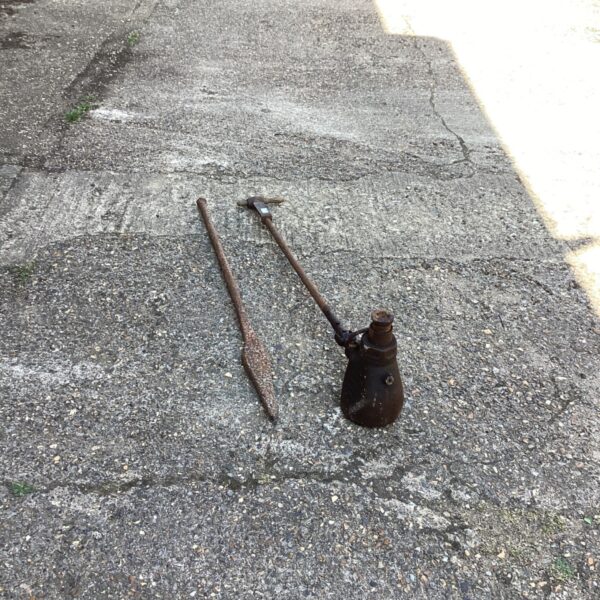 Vintage tractor jack with breaker bar, antique farm equipment.