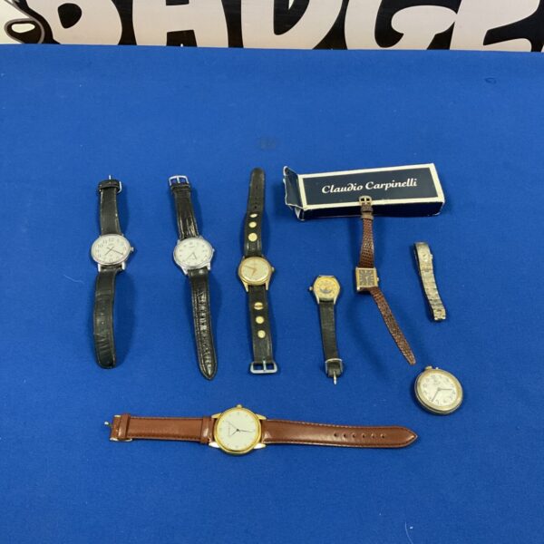 Vintage wrist watch lot on a blue background.