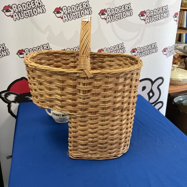 Vintage wicker stairs basket with a woven design and sturdy handle.