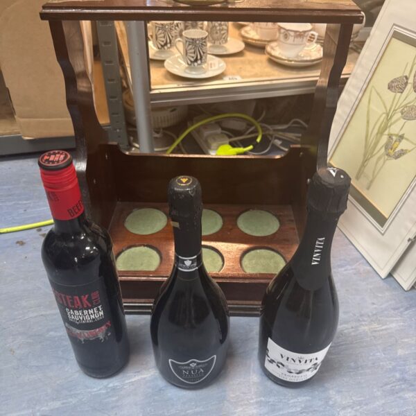 Vintage wooden wine bottle rack holding prosecco and wine.