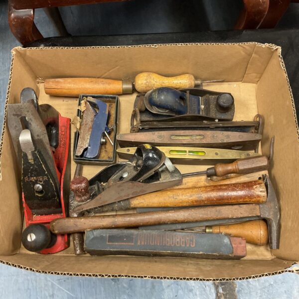 Vintage wood planes and spirit levels in a tool lot.