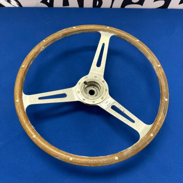 Vintage wood steering wheel with metal spokes, classic car part.