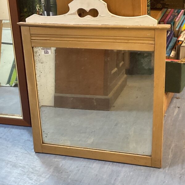 Vintage wooden mirror with a rustic frame and aged appearance.