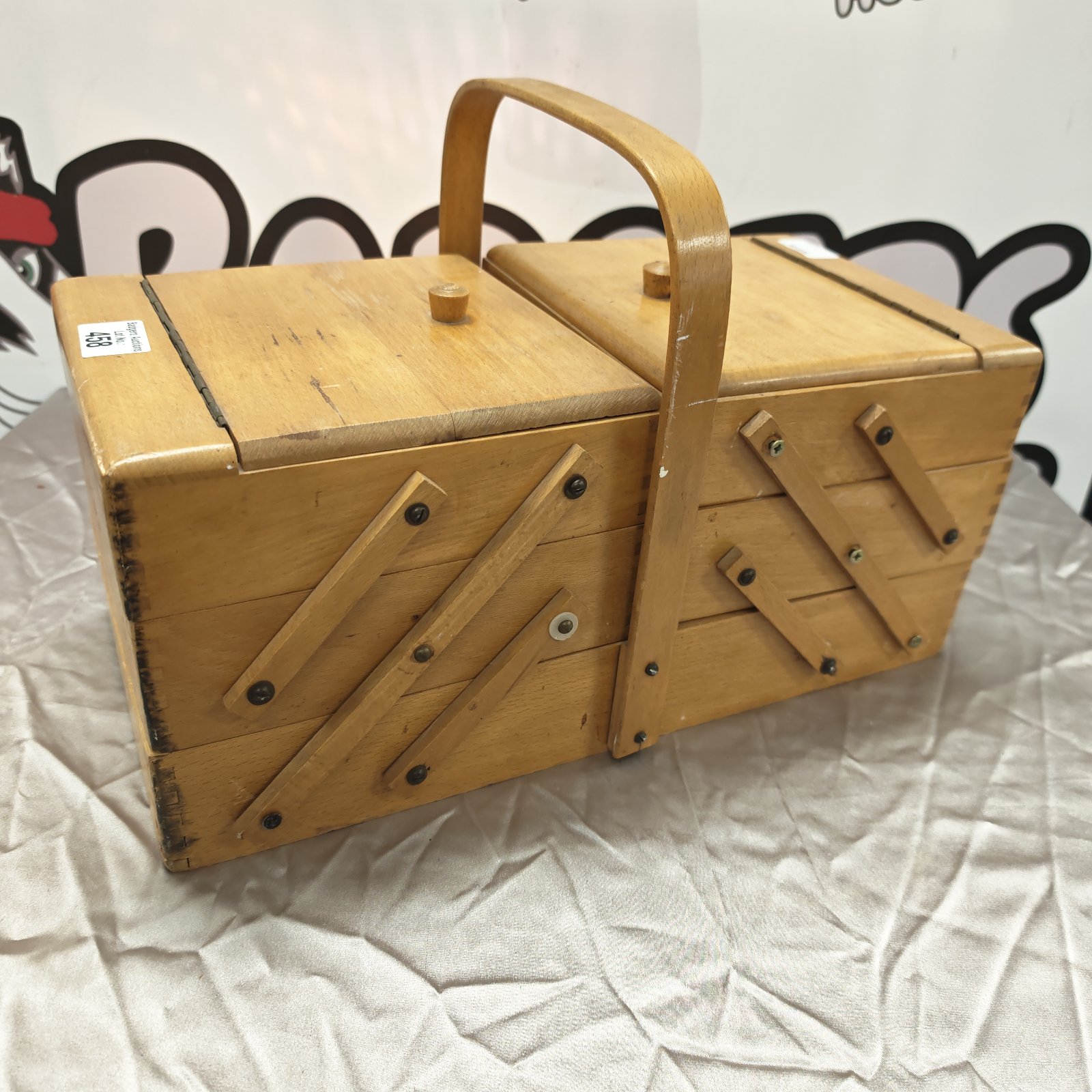 Vintage wooden sewing box with handle and hinged lid.