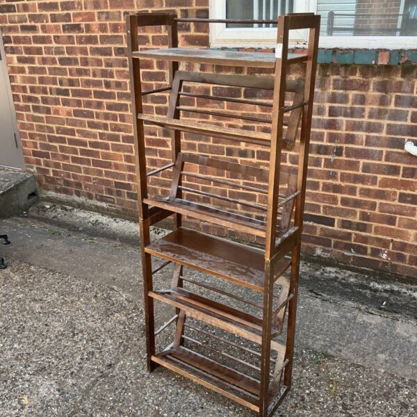 Vintage wooden shoe rack against brick wall.