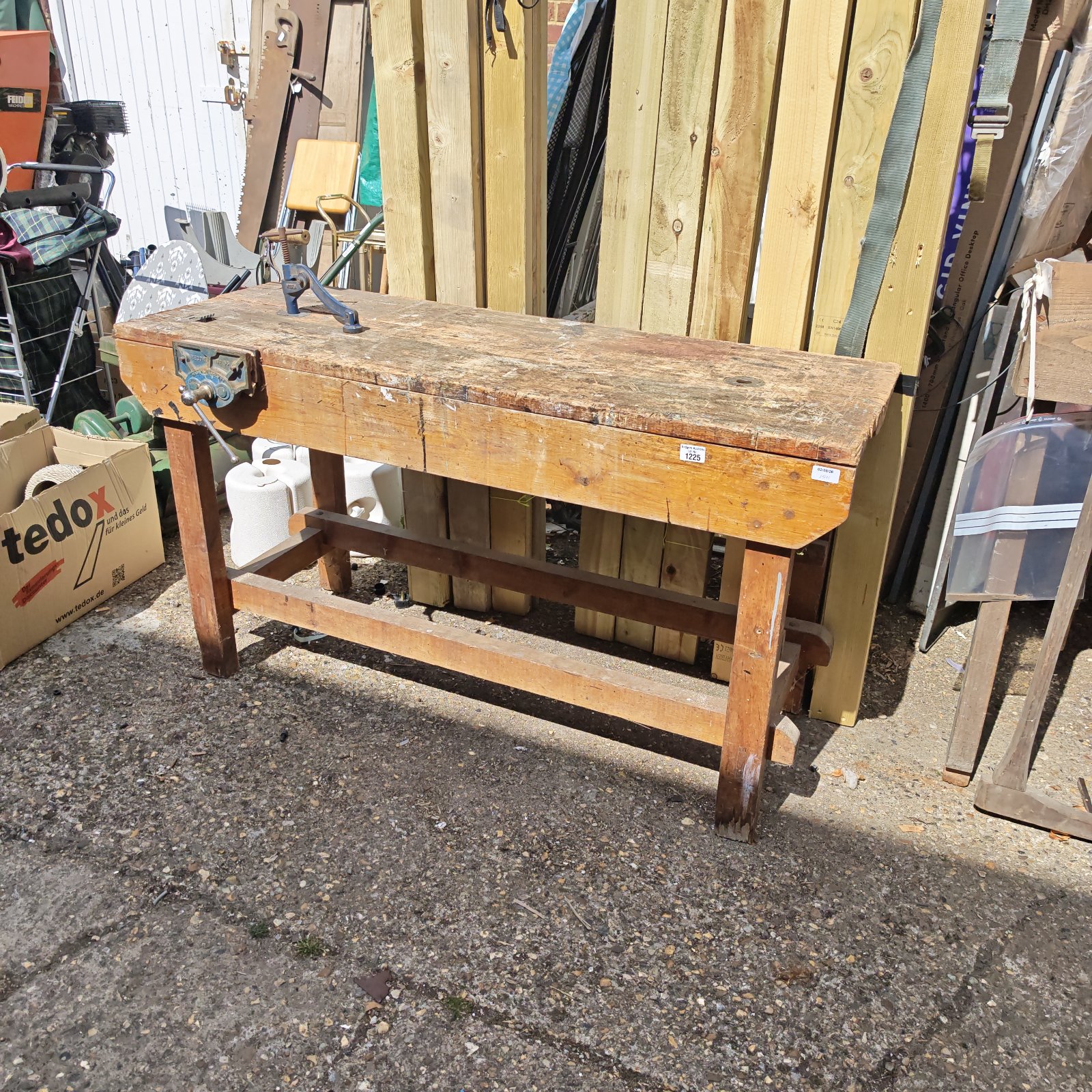 Vintage workshop bench with vice and clamp, ideal for woodworking projects.