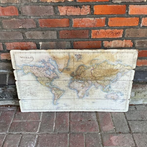 Vintage world map print on board, detailed geographical illustration.