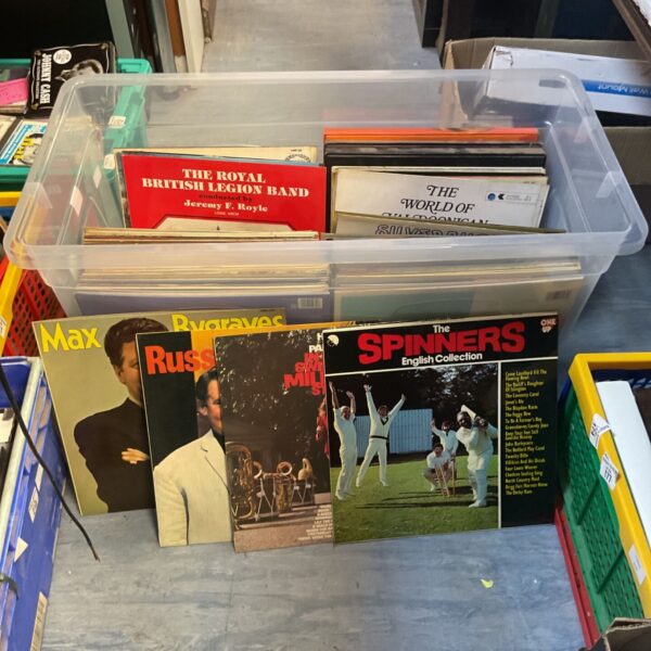 Vintage vinyl record collection in a clear container.