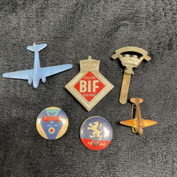 Collection of vintage wartime badges, including aviation insignia.