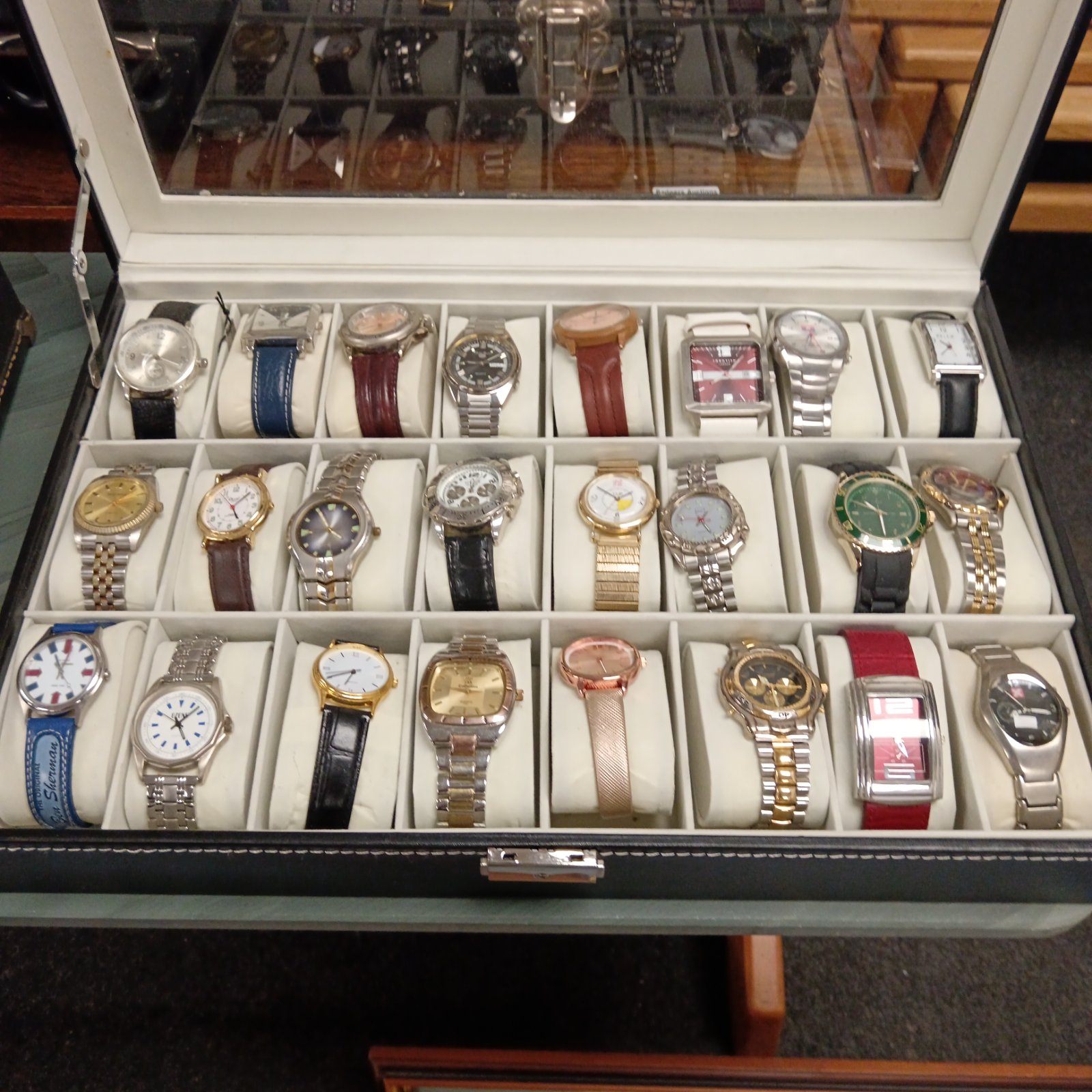 Watch collection in display case featuring vintage and modern timepieces.