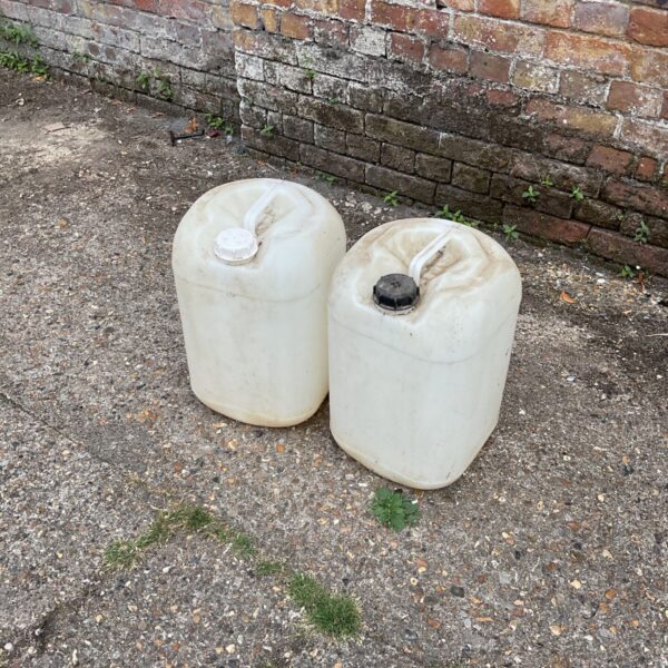 Two plastic water barrels for garden storage.