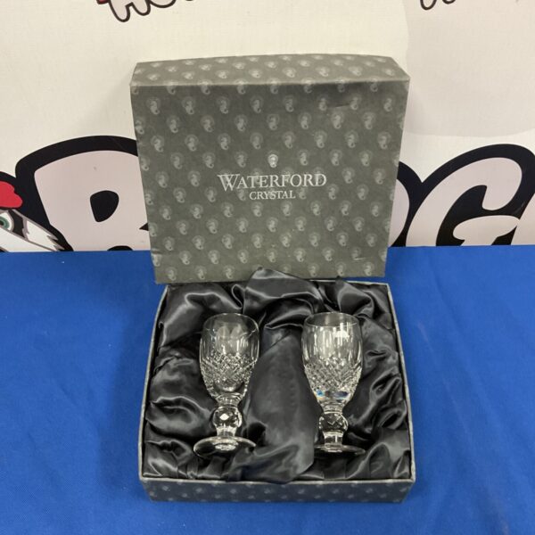 Pair of Waterford crystal liqueur glasses with intricate cut detailing.
