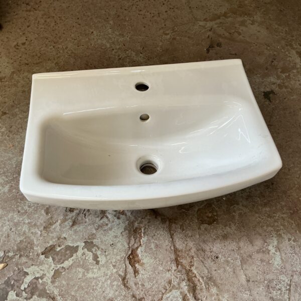 White ceramic basin with tap holes for bathroom use.