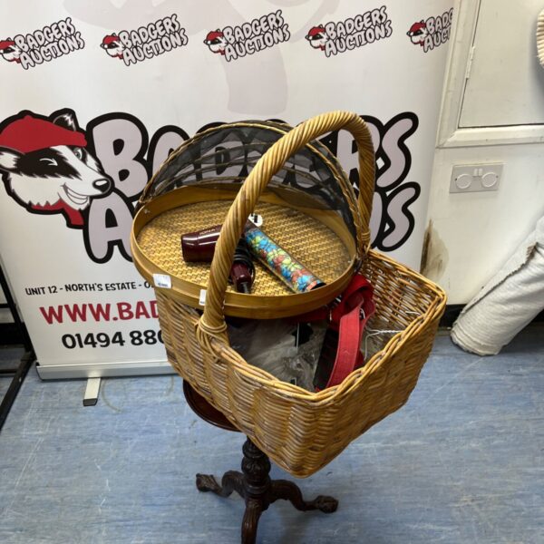 Wicker basket filled with various household items and a hairdryer.