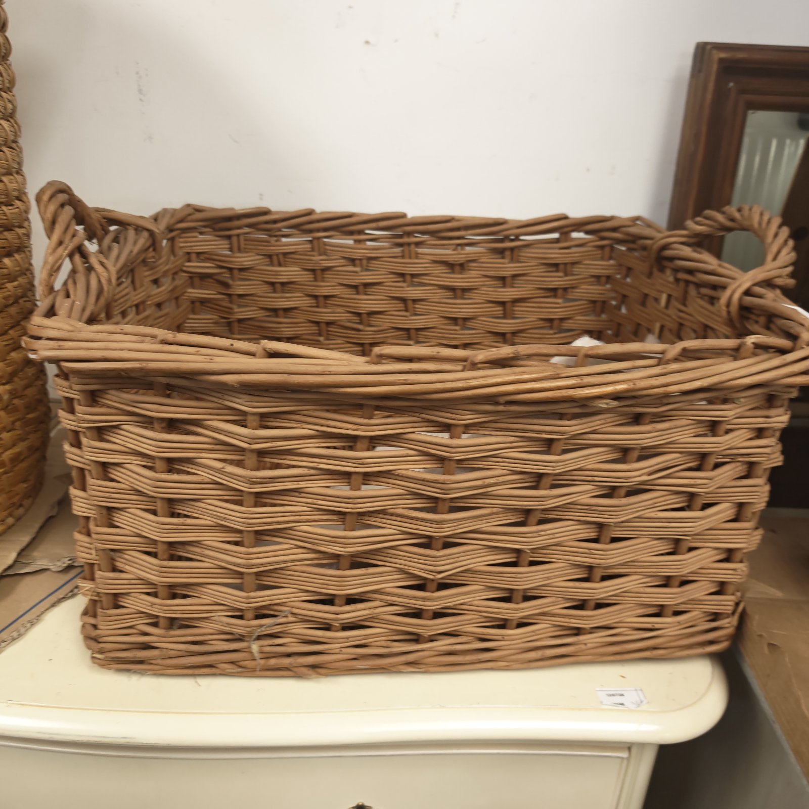 Rectangular wicker basket with handles, ideal for storage.