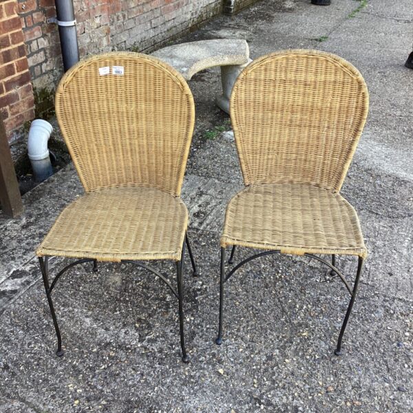Pair of vintage wicker garden chairs with black frames.