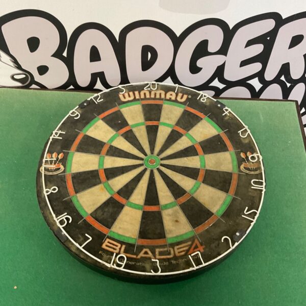 Winmau Blade dartboard with visible wear from use.