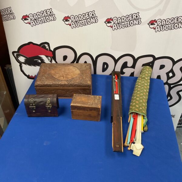 Vintage wooden boxes and knitting needles collection for crafting and storage.