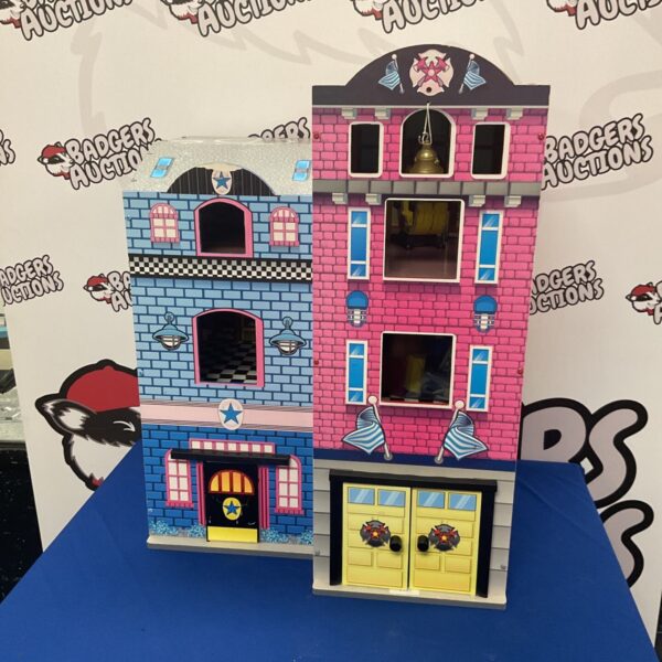 Colourful wooden fire station dollhouse with detailed exterior.