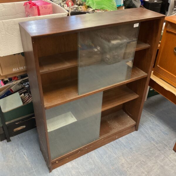 Vintage wooden bookcase with glass panels for home storage.