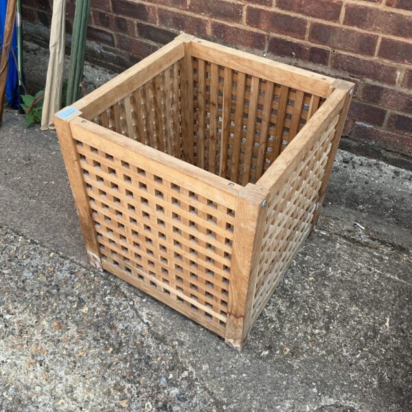 Square wooden planter box with lattice sides for garden plants.