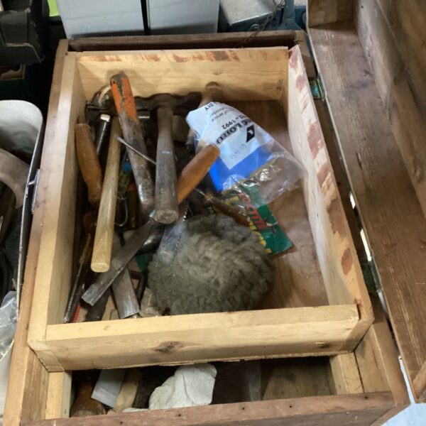 Vintage wooden tool case overflowing with antique hand tools.